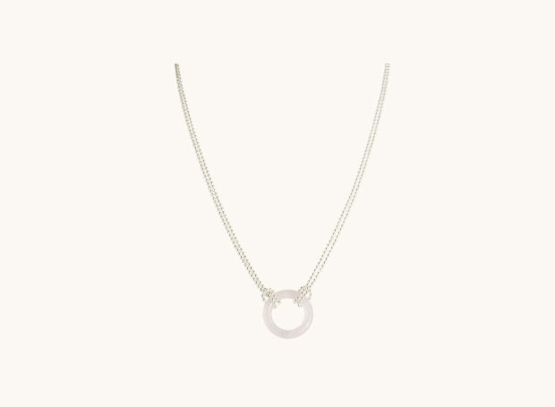 a rose quartz round pendant on a sterling silver chain